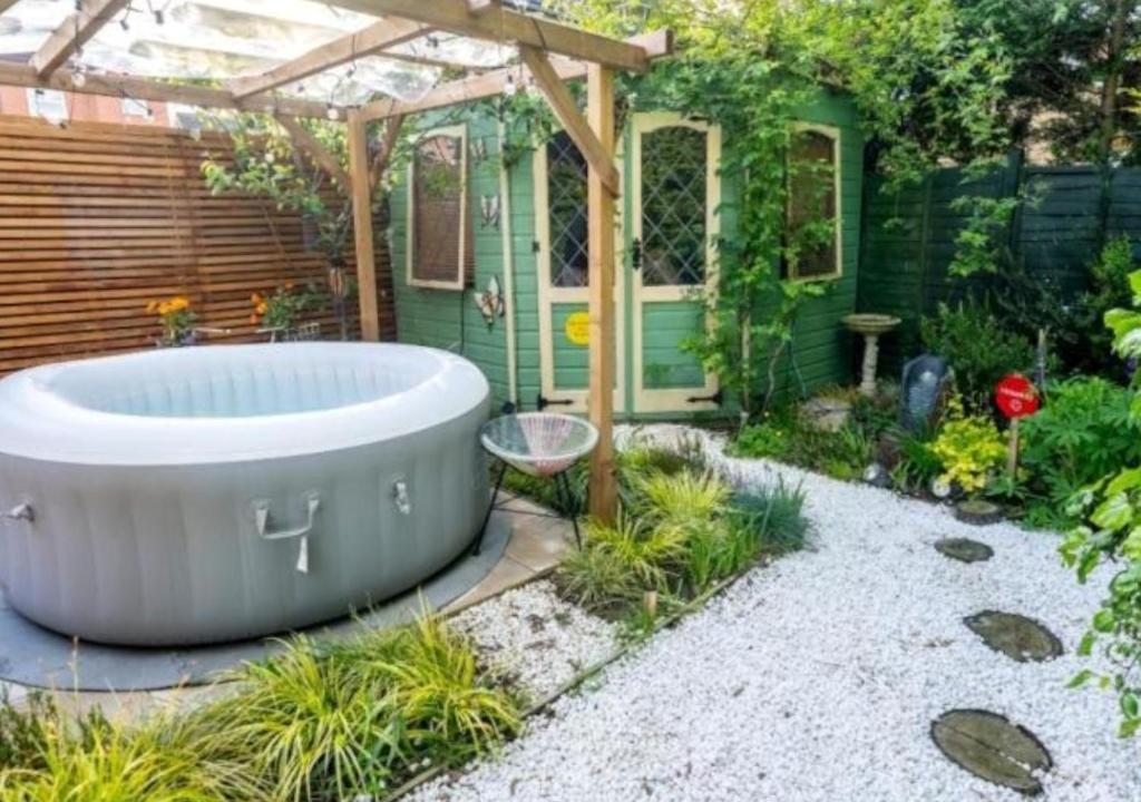 een hot tub in een tuin met een pergola bij Cosy Garden Flat, Private Roofed Hot Tub & Four Poster Bed in York
