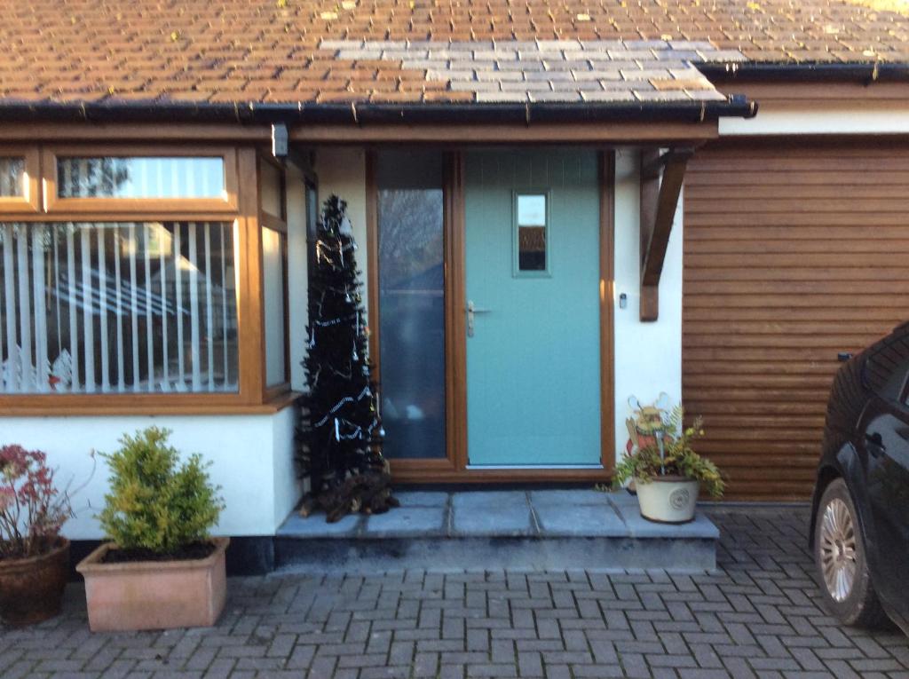 ein Haus mit blauer Tür und einigen Pflanzen in der Unterkunft The Burrows (ladybird lodgings) in Stoke Gabriel