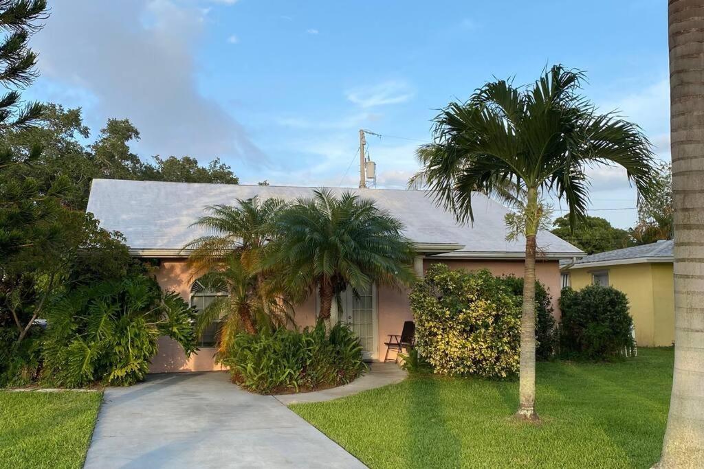a house with palm trees and a driveway at Vintage Vero Bungalow in Vero Beach
