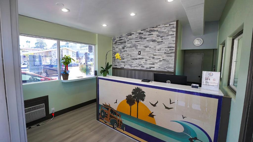 an office with a reception desk with a large painting at SeaSide Inn & Suites in Santa Cruz