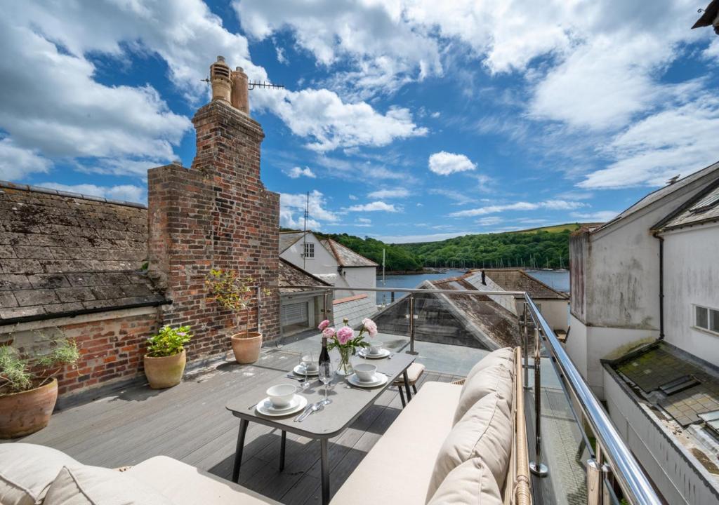 d'un balcon avec une table et une vue sur l'eau. dans l'établissement Pont View, à Fowey