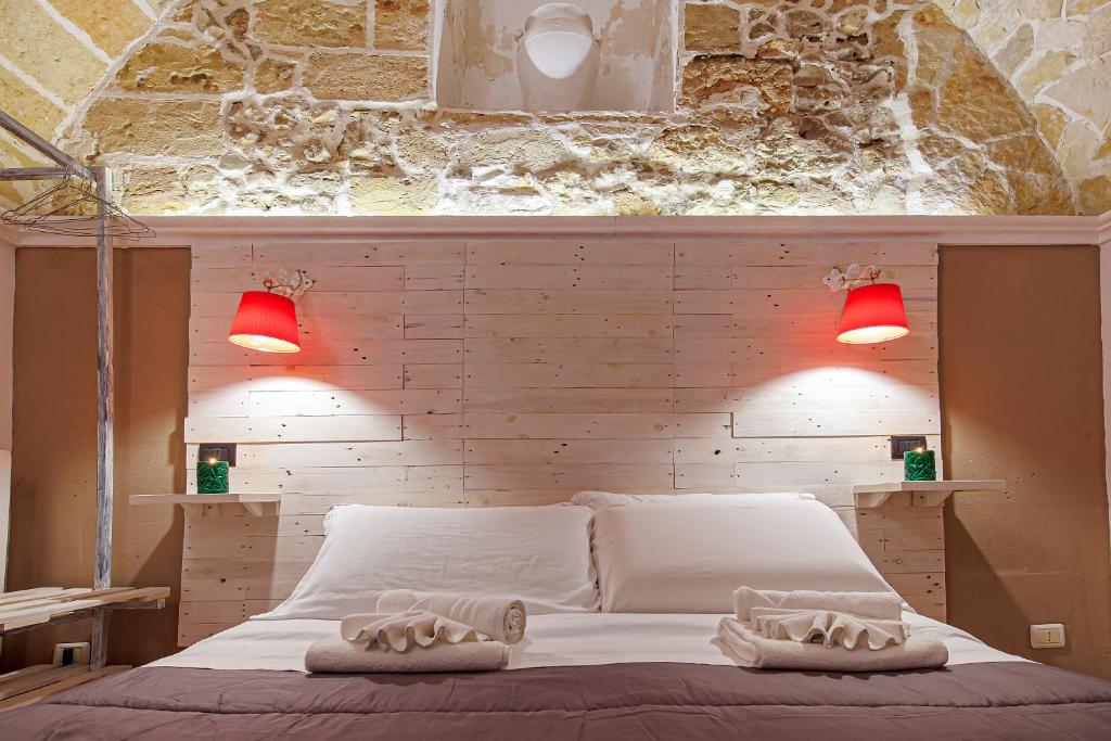 una camera da letto con un letto bianco e luci rosse di Exedra Holiday House a Leverano