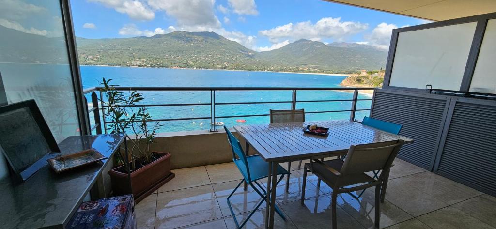 a balcony with a table and chairs and a view of the water at T2 de Standing Coté Plage, les pieds dans l'eau in Propriano
