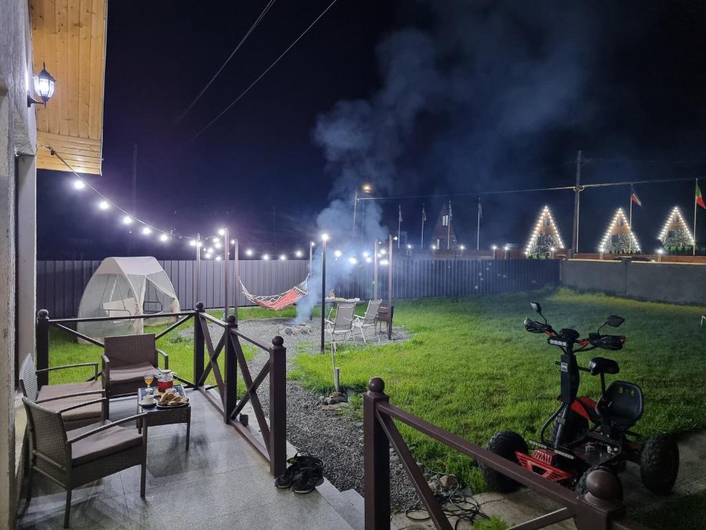 uma casa com uma tenda e uma moto num quintal à noite em Borjomi Plato house em Borjomi