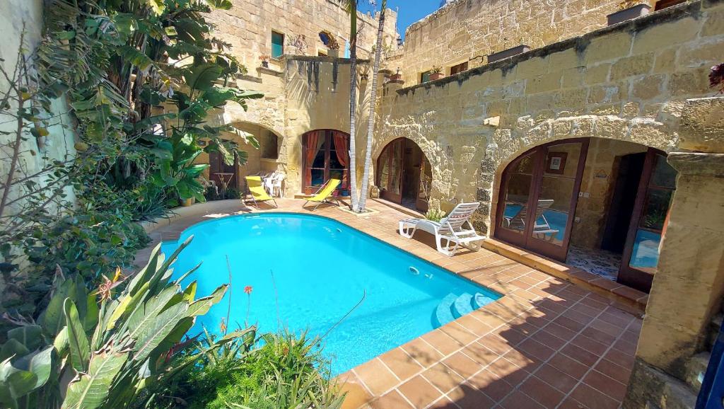 une piscine en face d'un bâtiment dans l'établissement Haven Farmhouse With Private Pool, à L-Għarb