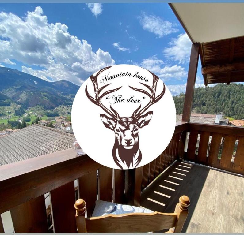 a sign on a balcony with a deer on it at mountain house the deer in Tesero