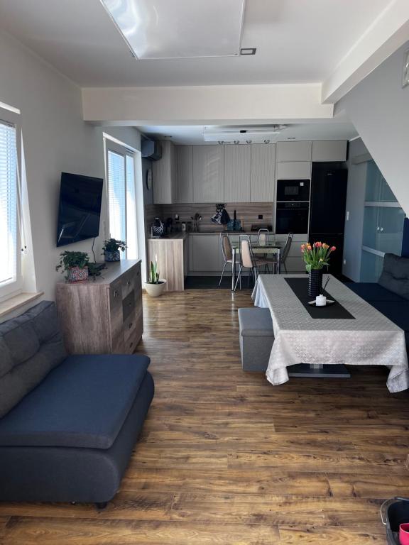 ein Wohnzimmer mit einem Sofa und einem Tisch in der Unterkunft Apartament LIDER na wyłączność in Słupsk