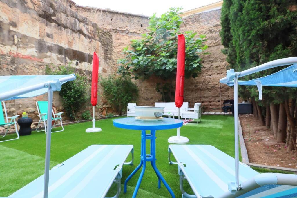 コルドバにあるcasa de los patios amuralladosのパティオ付きの庭にテーブルと椅子があります。