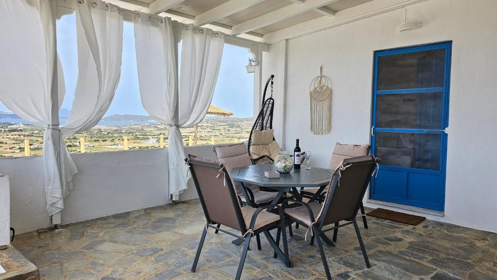 uma sala de jantar com uma mesa e cadeiras e uma janela em Bayview Villa Milos em Zefiría