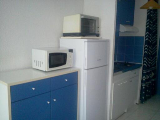 a microwave sitting on top of a refrigerator at Appartement F1 Calvi à 150 mètres de la plage in Calvi