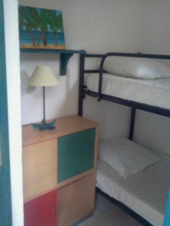 a bedroom with bunk beds and a desk with a lamp at Appartement F1 Calvi à 150 mètres de la plage in Calvi