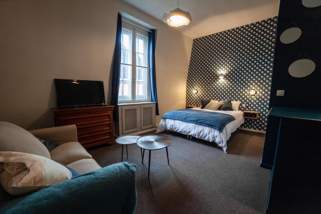 a bedroom with two beds and a tv and a couch at MAISON RENARD in Béthune