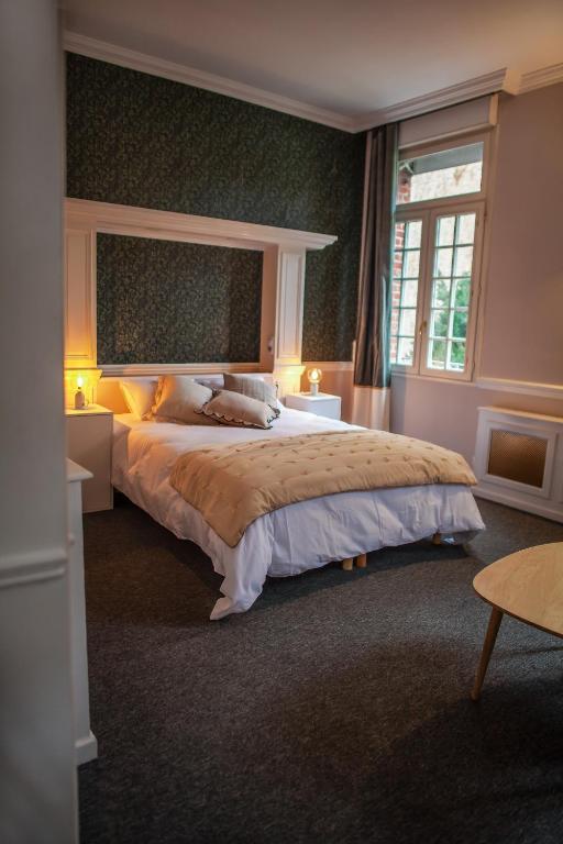 a bedroom with a large bed and a window at MAISON RENARD in Béthune