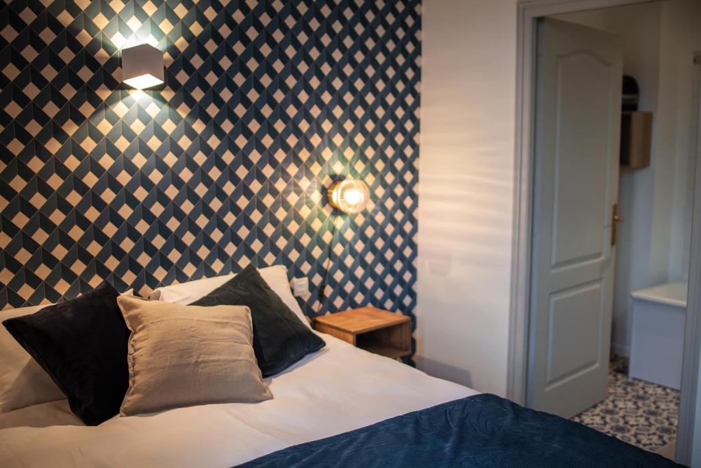 a bedroom with a bed with a black and white patterned wall at MAISON RENARD in Béthune