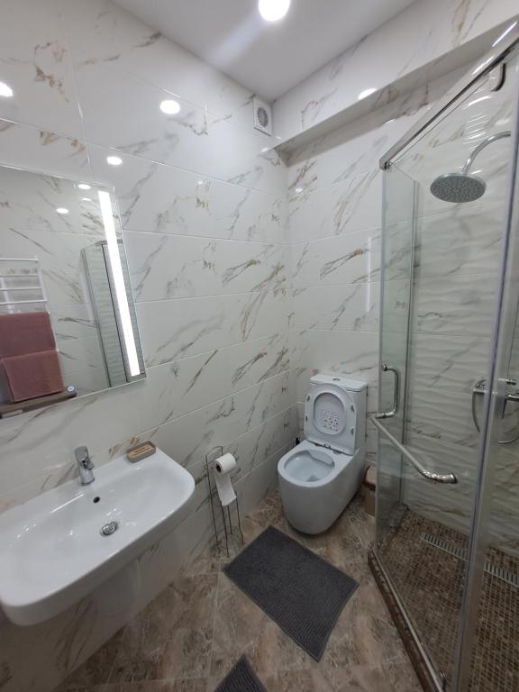 een badkamer met een wastafel, een toilet en een douche bij Chirie Apartament in Chişinău