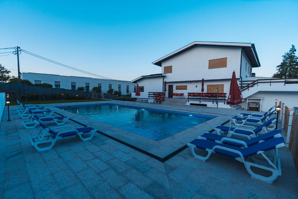 a swimming pool with lounge chairs next to a building at Quinta da Costinha in Alijó