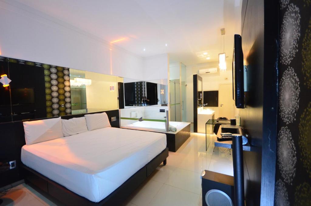 - une chambre avec un lit blanc et une salle de bains dans l'établissement VERT MOTEL MOSSORO, à Mossoró
