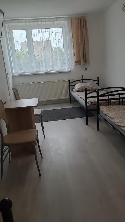 a room with two beds and a table and chairs at Noclegi in Starogard Gdański