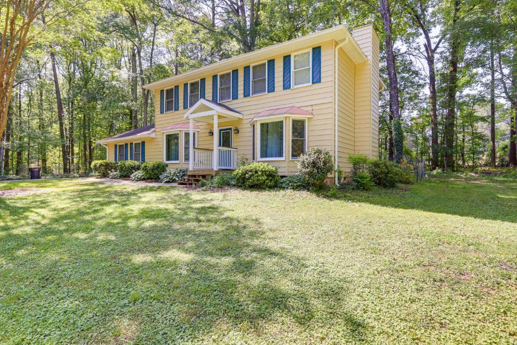 una casa amarilla con césped delante en Dog-Friendly Fayetteville Home with Fenced Yard!, en Fayetteville