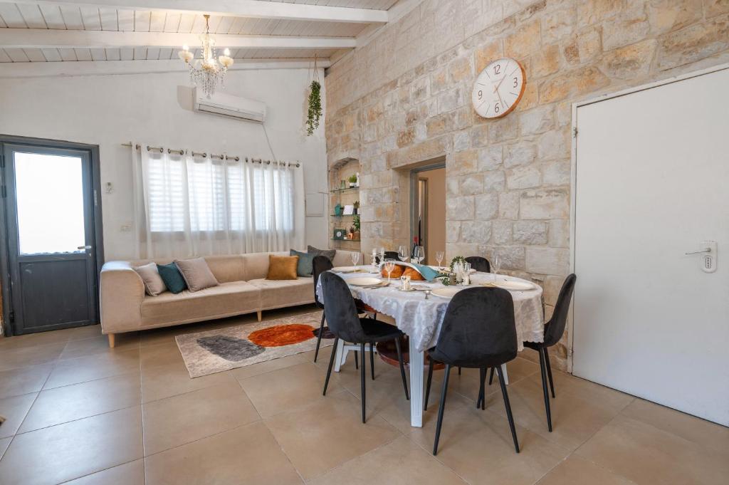 comedor y sala de estar con mesa y sillas en Nof Marom - the Home in the Old City נוף מרום - הבית בעתיקה, en Safed