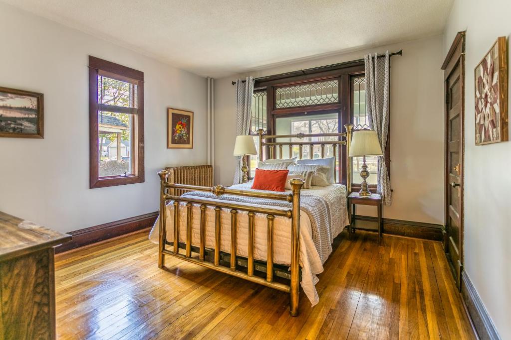 a bedroom with a bed and two windows at Cottage in the City - Historic Charm, Modern Touch in Saint Paul