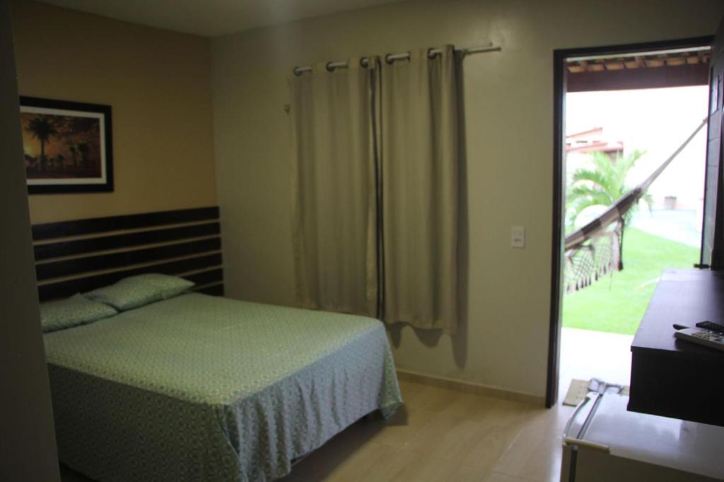 a bedroom with a bed and a sliding glass door at Pousada pôr do sol in Riachuelo