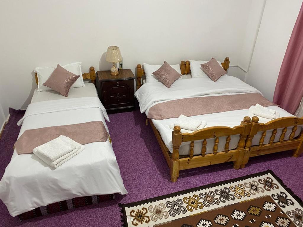 taila hostel في وادي موسى: سريرين يجلسون بجانب بعض في غرفة