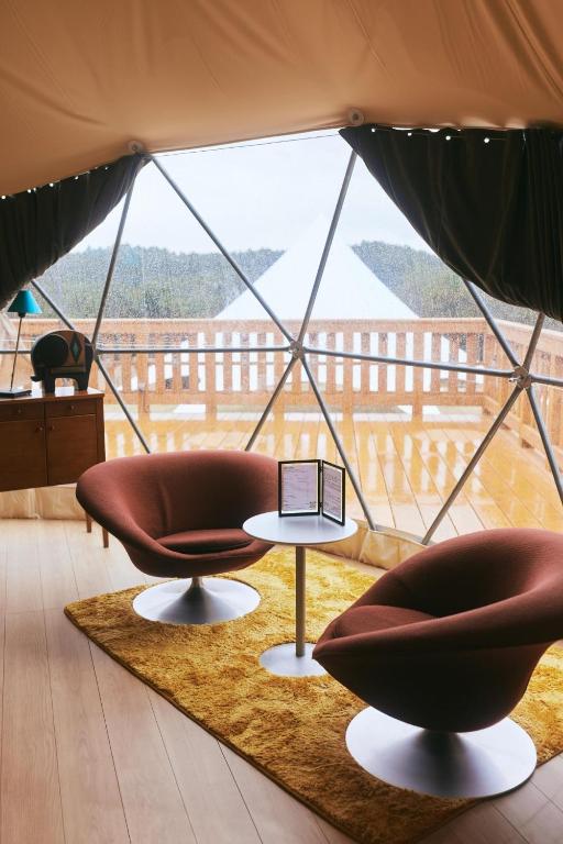 una camera con due sedie e un tavolo in tenda di Mitsuse base camp - Vacation STAY 52580v a Saga
