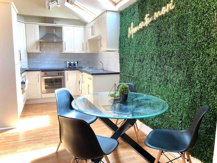 una pared verde en una cocina con mesa y sillas en Beautiful 2 bedroom apartment - close to beach, en Waterloo