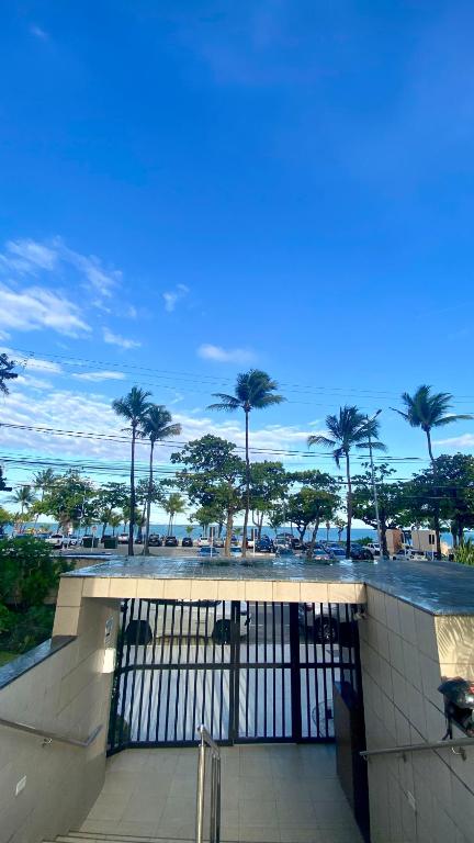 a view of a parking lot with palm trees and the ocean at Apartamento em Maceió com beira mar in Maceió