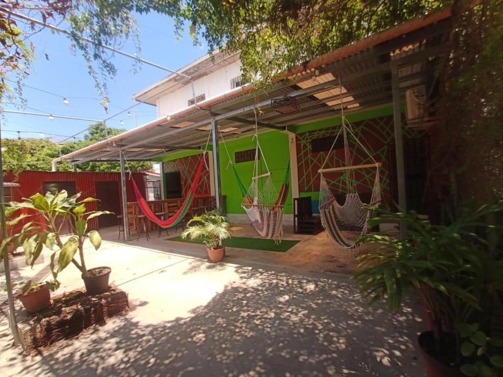 a house with swings and plants in front of it at Kawoq Hostel in San Ignacio