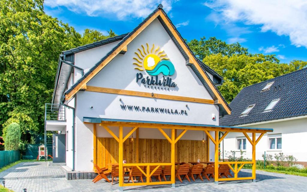 a building with a sign for a restaurant at Park Willa Trzęsacz in Trzęsacz