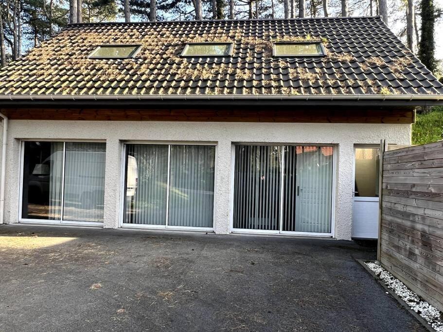 een huis met twee garagedeuren en een dak bij Maison indépendante de vacances HARDELOT PLAGE in Neufchâtel-Hardelot