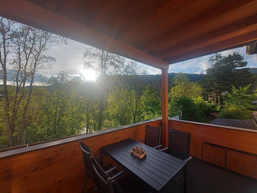 uma mesa e cadeiras num alpendre com vista em AusZeit Steiraland 8 mit überdachten Balkon und Parkplatz em Leoben