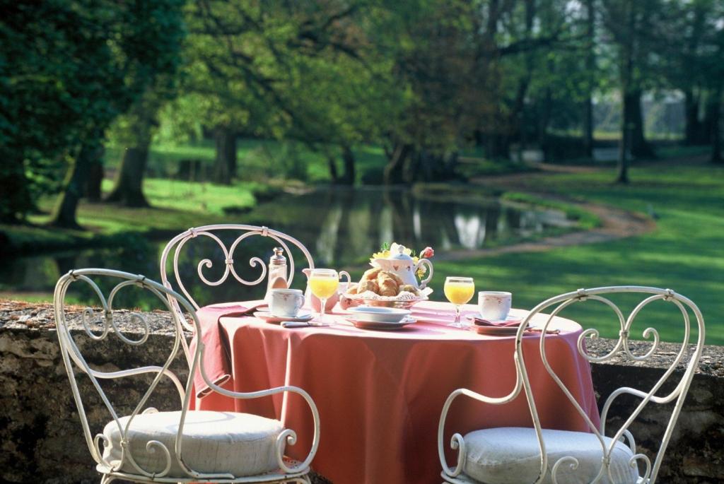 - une table avec un service à thé et 2 chaises dans l'établissement Château de Rigny, à Gray