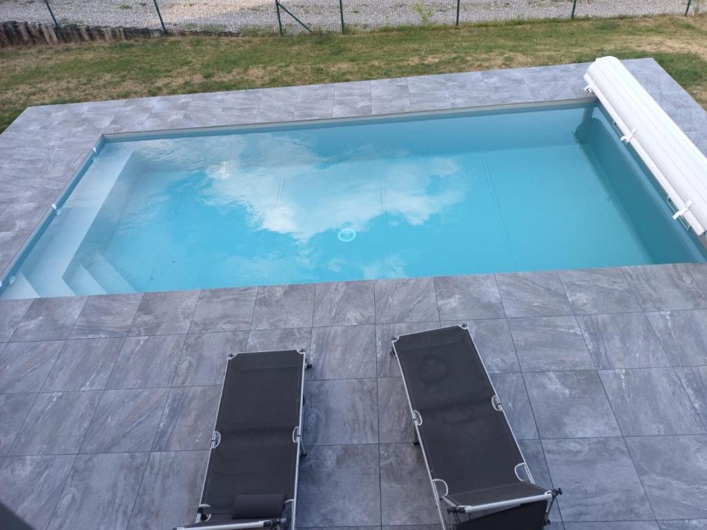 2 sedie e una piscina con acqua blu di chambre gite au pied du Vieil Armand a Wattwiller