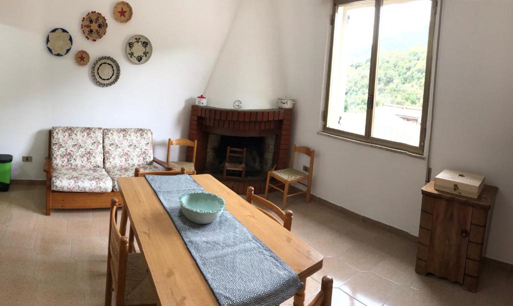 uma sala de jantar com uma mesa e cadeiras e uma lareira em La Corbula - Casa Vacanze - Q5992 em Fluminimaggiore