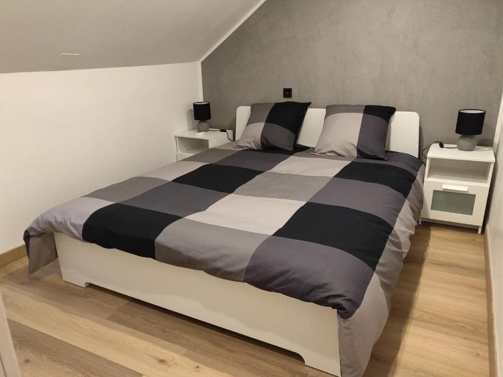 a bedroom with a black and white bed with two night stands at Le business, duplex moderne special PRO de passage in Sarreguemines