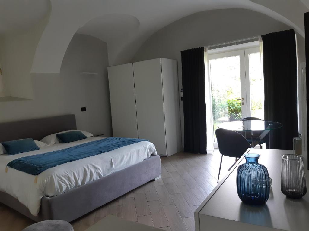 a bedroom with a bed and a table and a window at Sweet Home Canavese in Castellamonte