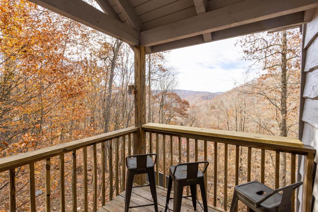 a screened porch with two chairs and a view of the mountains at Whiskey Ridge in Boone