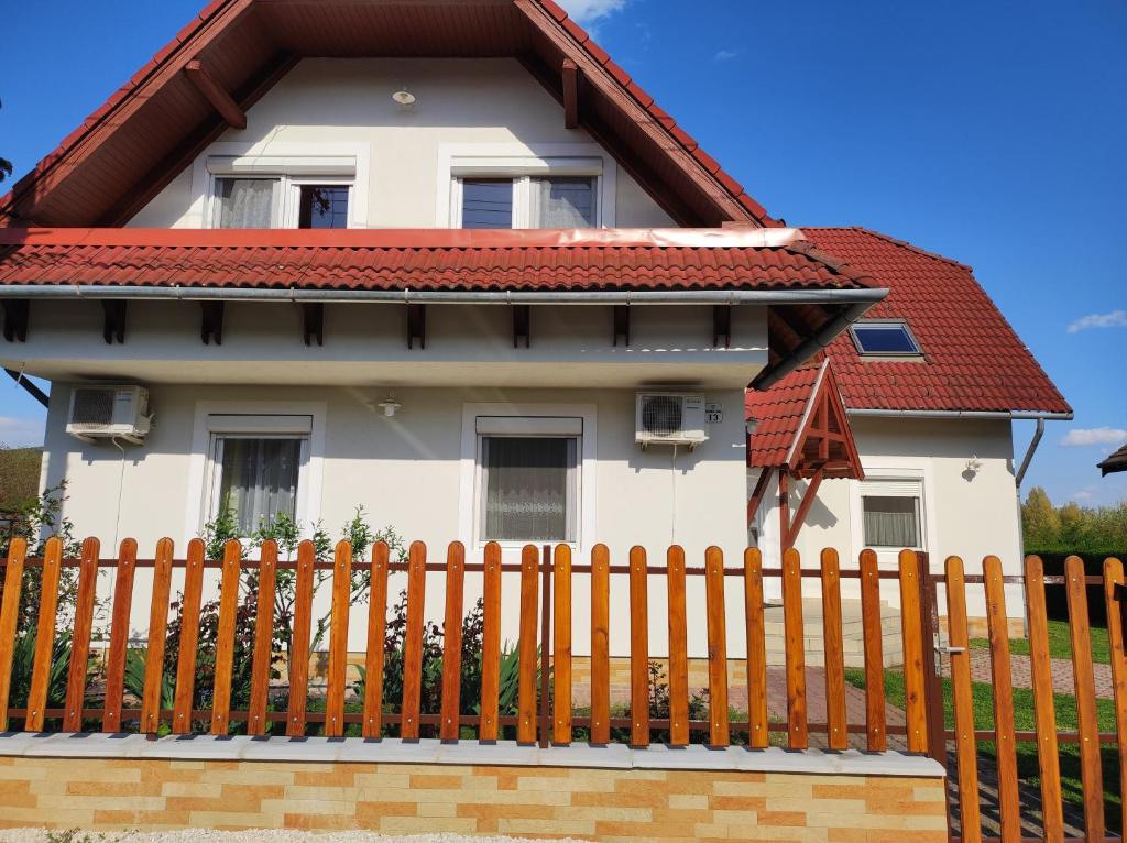 a house with a fence in front of it at Badacsony Apartmanház in Badacsonytomaj
