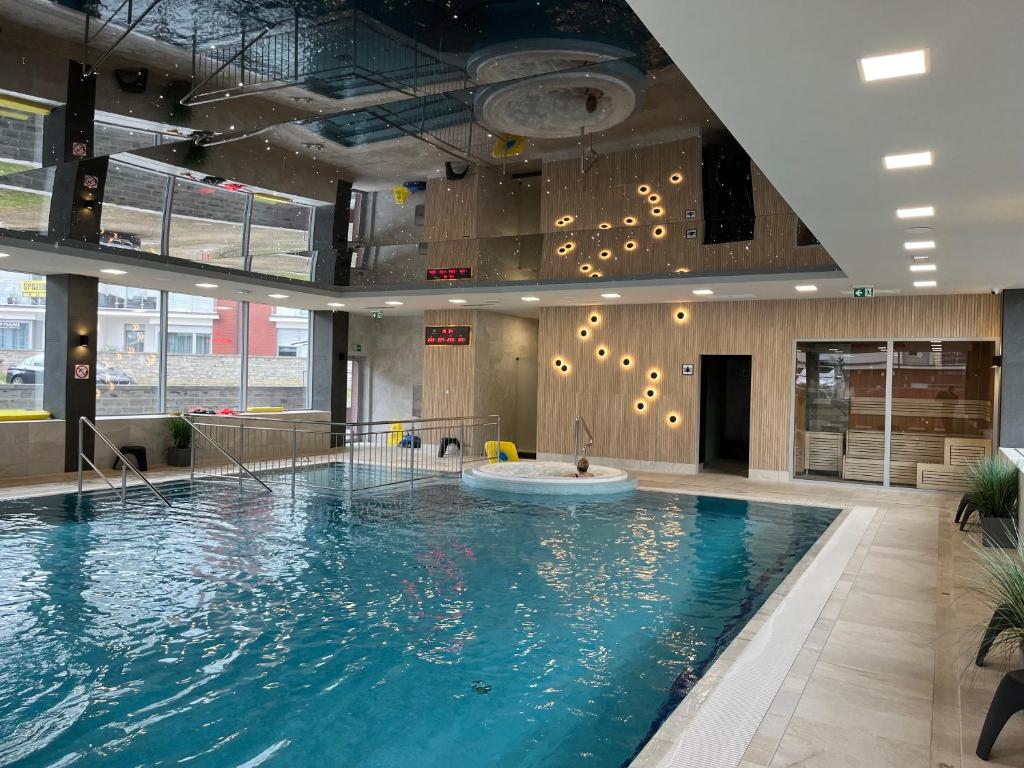 a large swimming pool in a building with a large pool at Apartament KLIFOWA REWAL przy plaży in Rewal