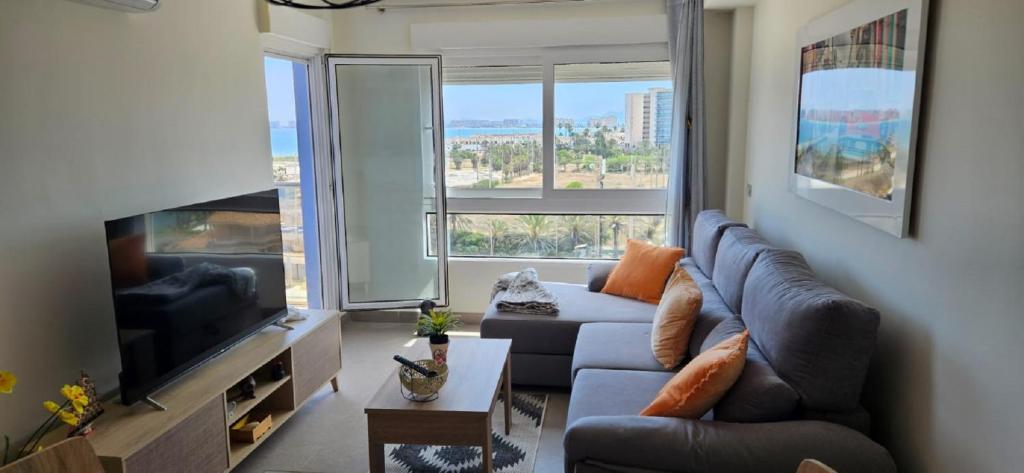 a living room with a couch and a large window at BEACH SUN SPIRIT, spa & gym in La Manga del Mar Menor