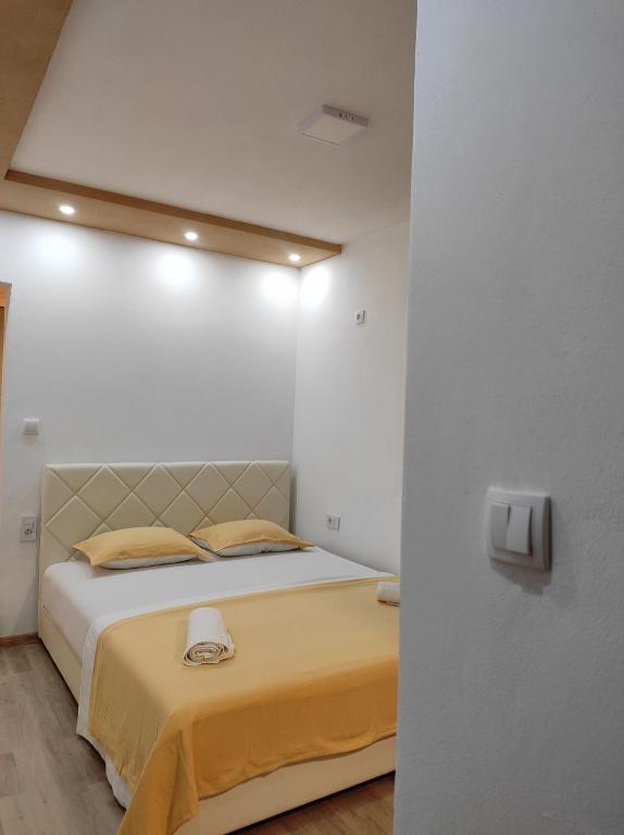 a bedroom with a large bed with a yellow blanket at Vila Zara in Donji Štoj