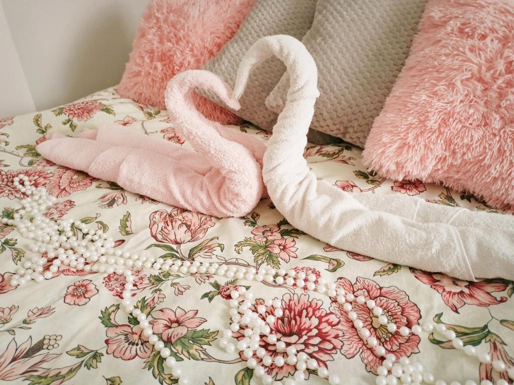 Dois flamingos cor-de-rosa sentados em cima de uma cama em Apartament Celebrity em Leśna
