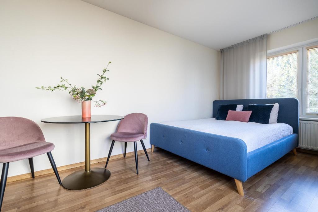 1 dormitorio con 1 cama, mesa y sillas en Mare Apartments, en Palanga