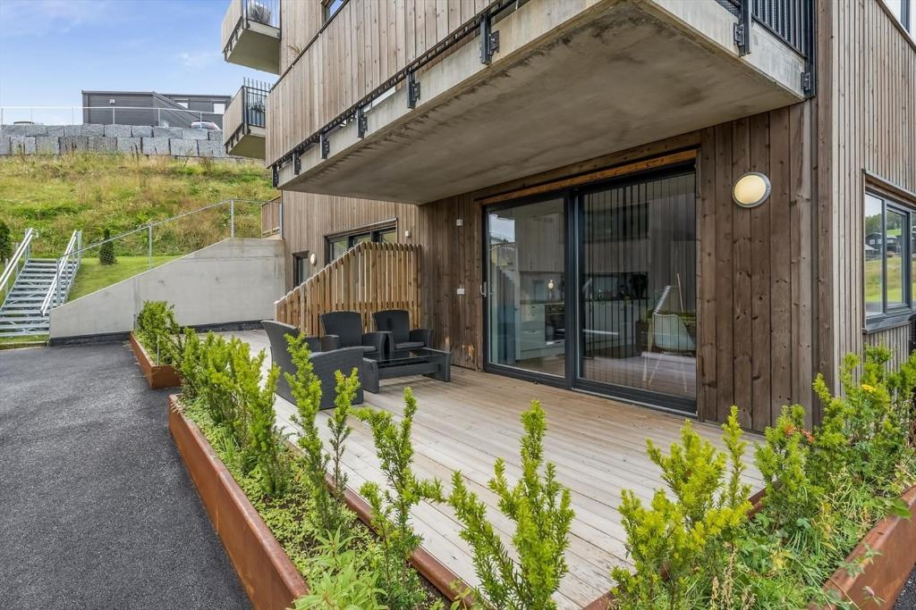 ein Haus mit einer Holzterrasse und einer Terrasse in der Unterkunft Apartments in Kjeller Lillestrøm - New, Modern and Central in Lillestrøm