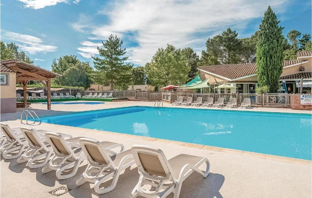 une piscine avec des chaises longues et une piscine dans l'établissement Mazet Provençal dans Village Vacances, à Gaujac