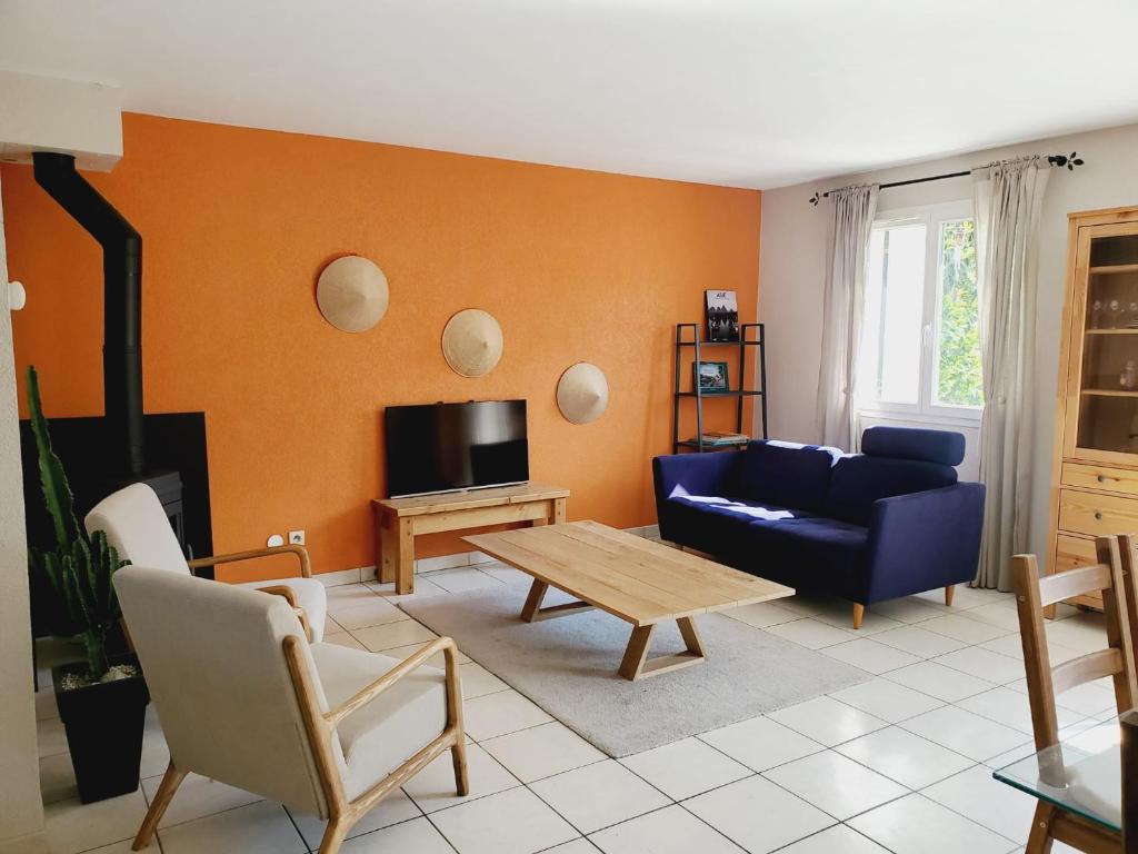 sala de estar con sofá azul y mesa en Maison Gradina - Séjour à Annecy entre lac et montagne en Metz-Tessy