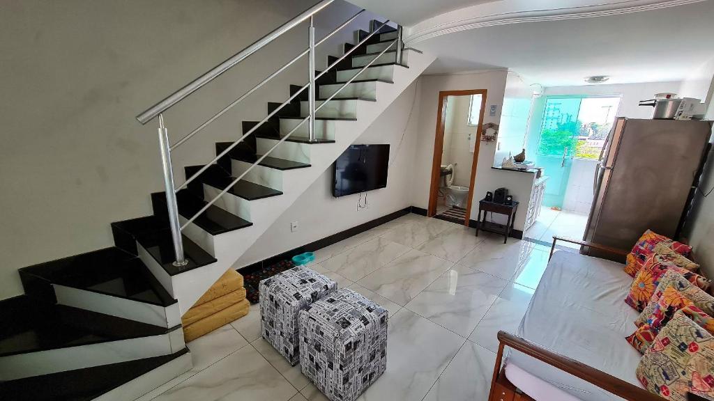 een woonkamer met een trap in een huis bij Casa confortável e segura na região da Pampulha in Belo Horizonte
